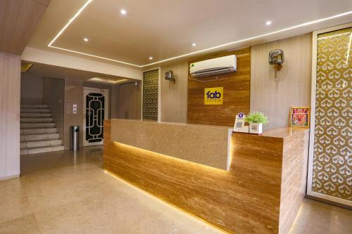 a hotel lobby with a reception desk and stairs at FabHotel Surya in Bhopal