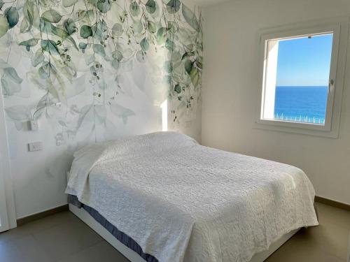 een slaapkamer met een bed met een bloemrijke muur bij villetta Sole Mare in Santo Stefano al Mare