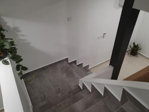 eine Treppe in einem Haus mit einer weißen Wand in der Unterkunft Number A Homestay in Raub