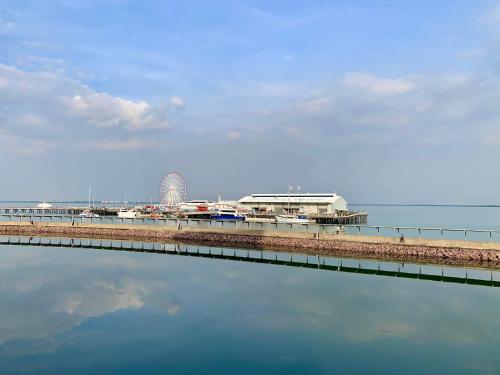 a pier next to the water with a beach at Serenity Harbour Views at Darwin Waterfront in Darwin