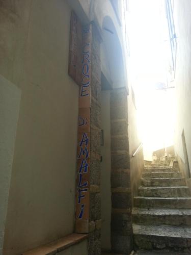 a cross on the side of a wall with stairs at Hotel Croce Di Amalfi in Amalfi