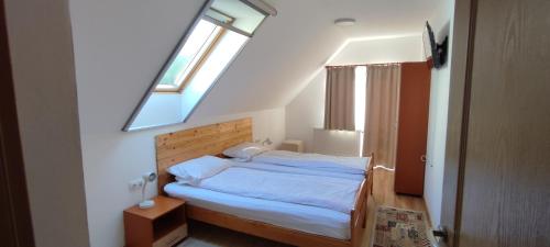 a bedroom with a large bed with a skylight at Olt-Part Vendégház in Băile Tuşnad