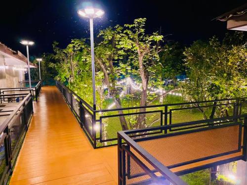 a balcony with benches and a street light at night at บ้านต้นไม้โฮมสเตย์อุทัยธานี in Uthai Thani