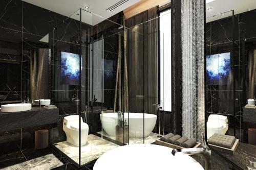 a bathroom with two toilets and a tub and a sink at M Resort & Hotel Kuala Lumpur in Kuala Lumpur