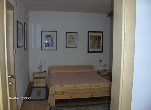una camera con un letto e tre immagini sul muro di villa mahlfertheiner a Castelrotto