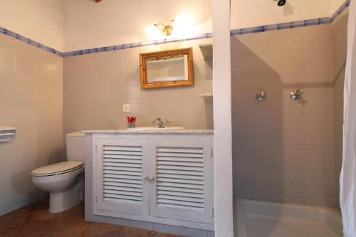 a bathroom with a sink and a toilet and a mirror at Holiday home Can Pontico in Pollença