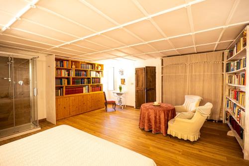 a living room with a table and chairs and bookshelves at Book and Bed in Orvieto