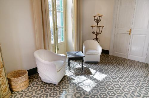 two white chairs and a table in a room at Maison Canopée in Messina