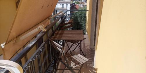 una silla de madera sentada en un balcón junto a una barandilla en Il Sole del Mediterraneo, en Noto