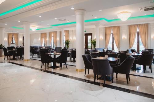 a restaurant with tables and chairs in a lobby at Pałac Uniejów in Uniejow