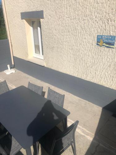 a table and chairs in front of a building at La Maison du Pêcheur in Portbail