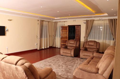 a living room with two chairs and a couch at The Meru Manor in Meru
