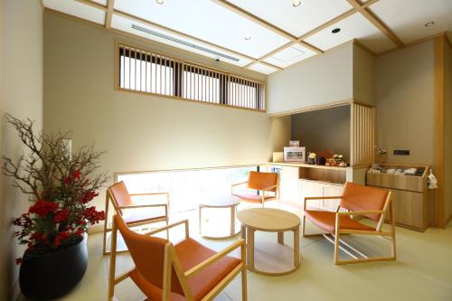 a room with chairs and a table and a kitchen at Onyado Nono Matsumoto Natural Hot Spring in Matsumoto