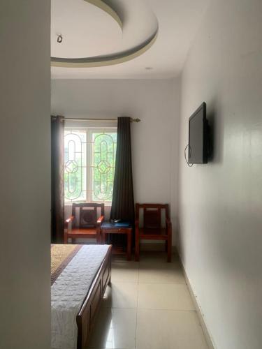 um quarto com uma cama, uma televisão e uma janela em Motel TÂY HỒ em Hai Phong