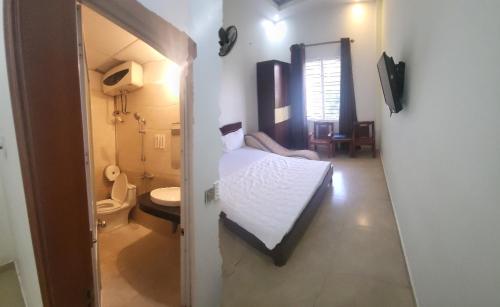 um quarto com uma cama e uma casa de banho com um WC em Motel TÂY HỒ em Haiphong