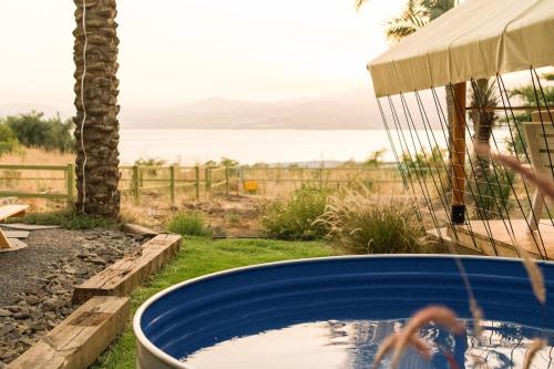 a hot tub in a yard with a view of the ocean at Sky Glamping boutique in Moshav Ramot