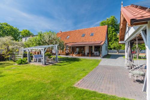 a garden with a swing and a house at Przystanek Jantar - pokoje i apartamenty in Jantar