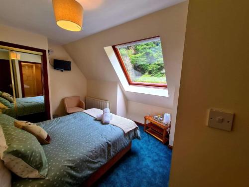 a small bedroom with a bed and a window at Braelea in Spean Bridge