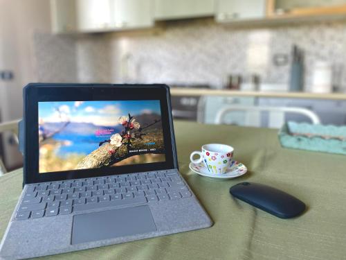 a laptop computer sitting on a table with a cup of coffee at MaGio House in Iseo