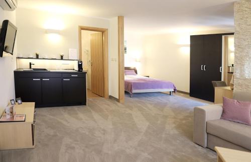 a living room with a bed and a couch at Hotel Villa Margaret in Malinska