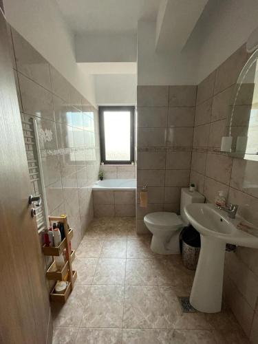 a bathroom with a toilet and a sink and a tub at PENSIUNEA CAMELIA in Baia
