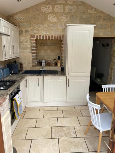 a kitchen with white cabinets and a tile floor at 71 Main Street in Bishopthorpe