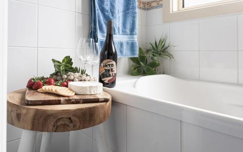 a bathroom with a bottle of wine and a cutting board at Carrawaves 73 LaRonde in Carrickalinga