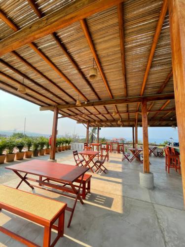 a patio area with tables, chairs and umbrellas at Casa Losodeli & Coworking- Adults Only in Puerto Escondido