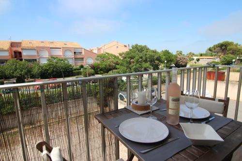 - une table sur un balcon avec vue sur un bâtiment dans l'établissement Studio climatisé tout confort à 2 pas de la mer avec parking privé, à Palavas-les-Flots