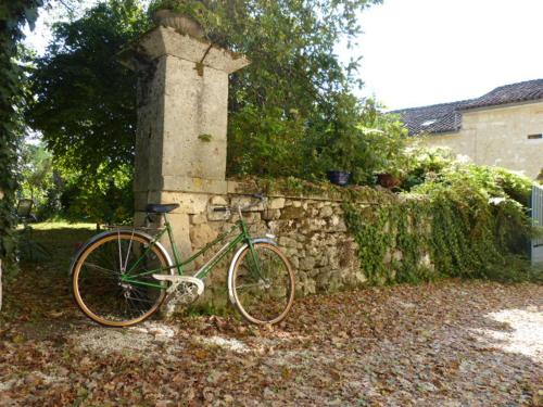 a green bike parked next to a stone wall at L'Echappée Belle Périgord in Cercles