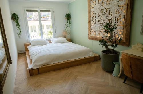 um quarto com uma cama com lençóis brancos e uma janela em Stadtwohnung im Herzen von Bern mit Pool em Berna