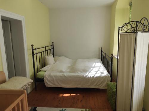 a bedroom with a bed with a metal frame at Schöne gemütliche Ferienwohnung am Saaleradweg in Großeutersdorf