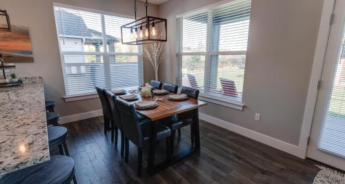 a dining room with a table and chairs and windows at Sunset Beach Manor - Oyhut Bay Seaside Village in Ocean Shores