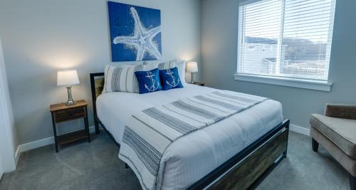 a bedroom with a bed with blue walls and a window at Sunset Beach Manor - Oyhut Bay Seaside Village in Ocean Shores