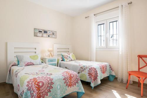 Un dormitorio con dos camas y una ventana. en Casa Orilla Sur A, en El Palmar
