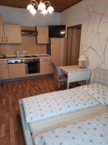 a room with a kitchen with a bed and a table at Gästehaus zur Post - Heritage Inn in Spital am Pyhrn