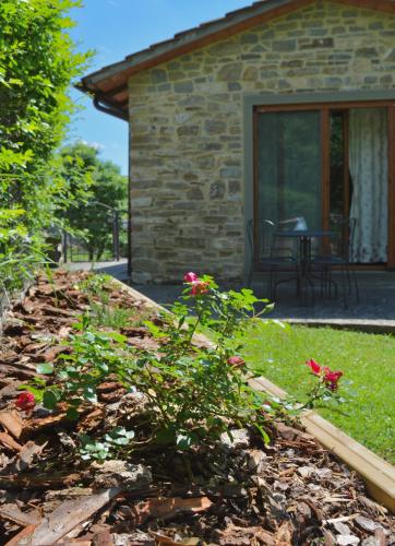 a garden in front of a stone house with flowers at Agriturismo Vezzano in Chiusi della Verna
