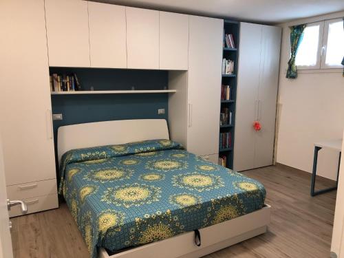 um quarto com uma cama e uma estante de livros em Appartamento a due passi dal centro storico di Imola em Imola