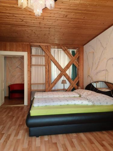 ein Schlafzimmer mit einem Bett in einem Zimmer mit Holzdecken in der Unterkunft Gästehaus zur Post - Heritage Inn in Spital am Pyhrn