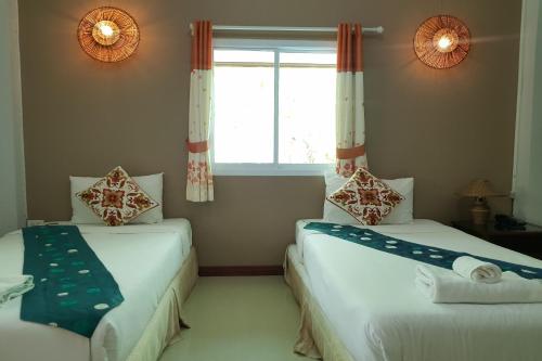 Giường trong phòng chung tại Pai Sukhothai Resort SHA Extra Plus