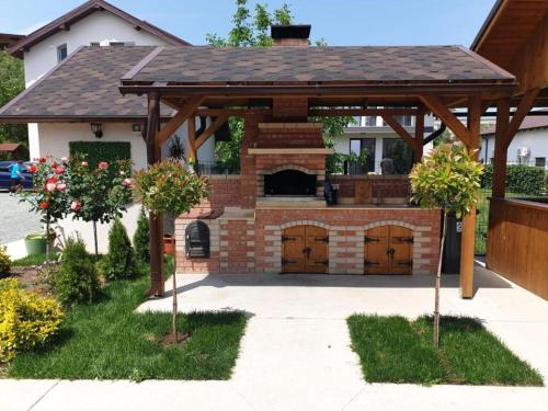 a wooden pavilion with two garage doors in front of a house at Vila Coty in Mamaia Nord