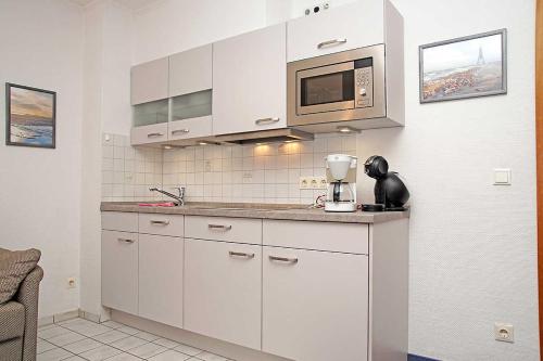 クックスハーフェンにあるFischerhus _ Wohnung 5のキッチン(白いキャビネット、電子レンジ付)