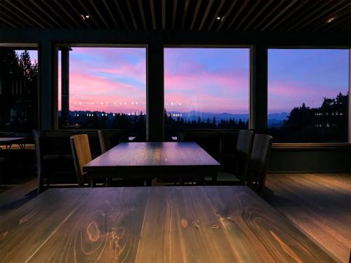 a table and chairs in a room with a view at kamosu mori in Tokamachi