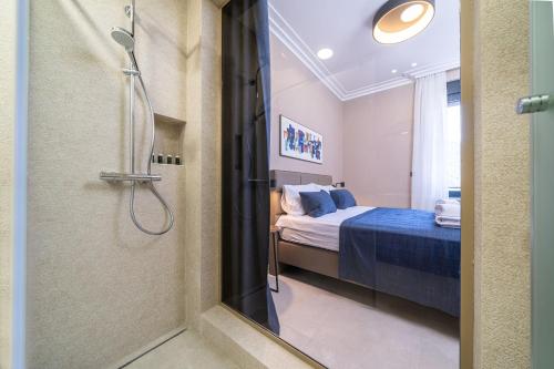 a bathroom with a shower and a bedroom with a bed at C Group apartments in Kotor