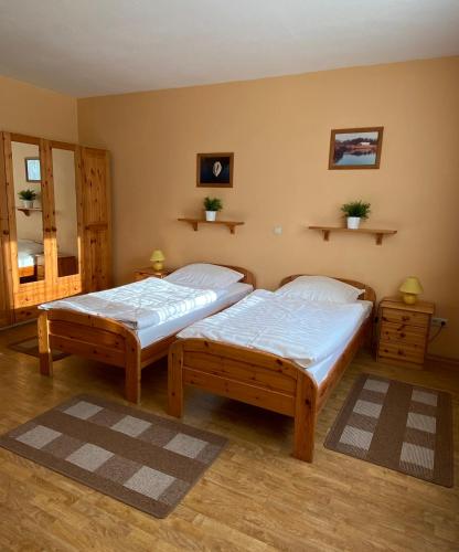 two twin beds in a room with wooden floors at Jägerhof Ostsee in Holm