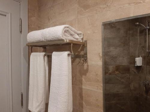 a bathroom with white towels on a towel rack at La Casa Beach in Hurghada