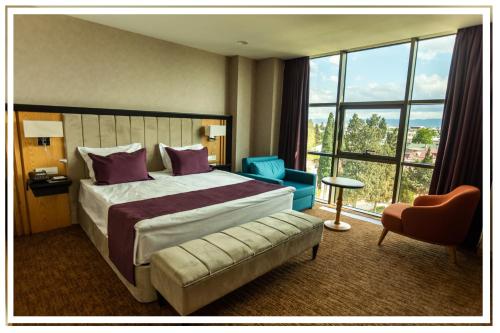 a hotel room with a bed and a large window at Premium Hotel Ganja in Ganja