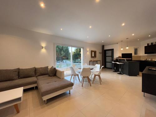 a living room with a couch and a table with chairs at Villa Bahia - bas de villa en pleine nature ! in Saint-Mitre-les-Remparts