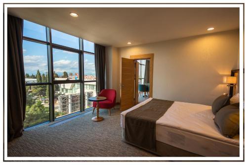 a hotel room with a bed and a large window at Premium Hotel Ganja in Ganja