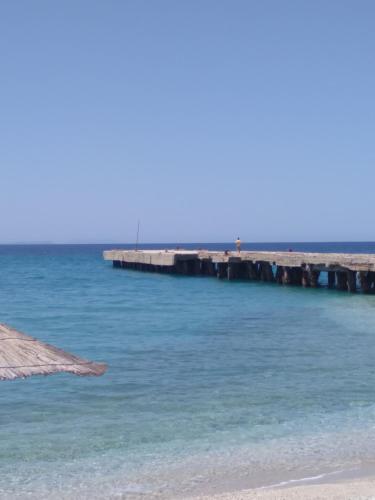 a pier in the water next to a beach at Villa Luiza Piqeras in Piqeras
